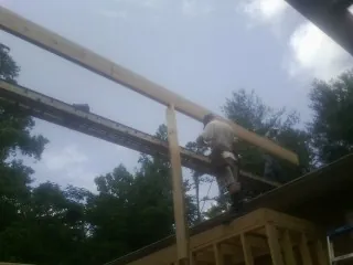 Carpenter setting a ridge beam over a new addition frame — Ice Dam Removal by Roofing Brothers in Muscoda