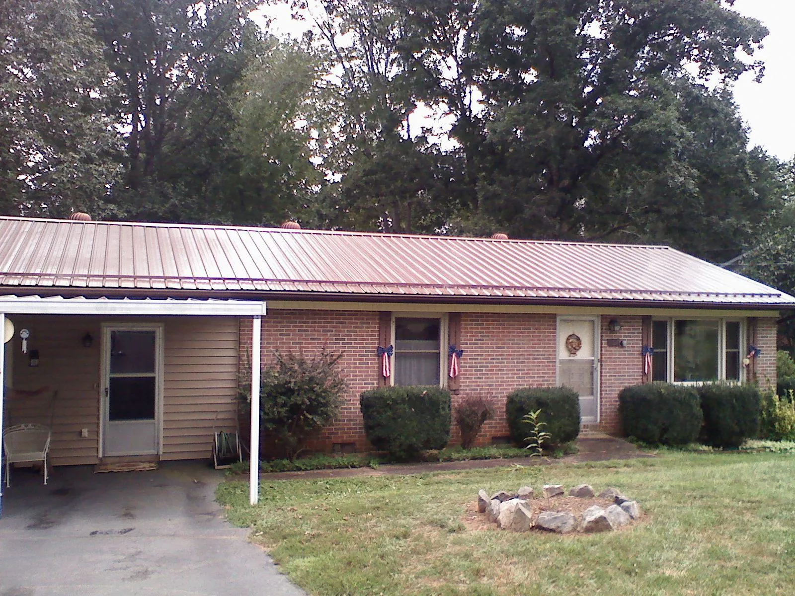Bronze metal roof and carport on a brick ranch home — Roof Repair work by our crew in Muscoda